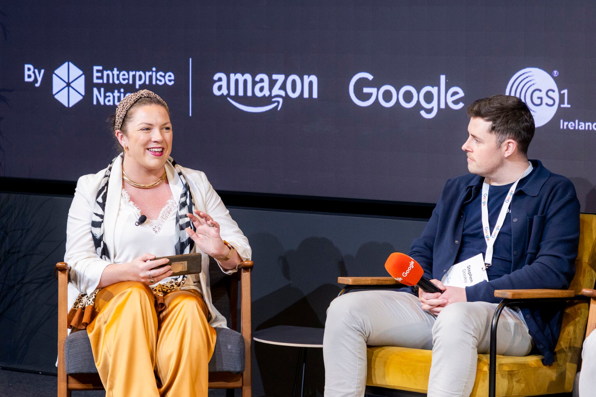 Tara Elzingre speaking on stage at an Enterprise Nation event with Amazon and Google